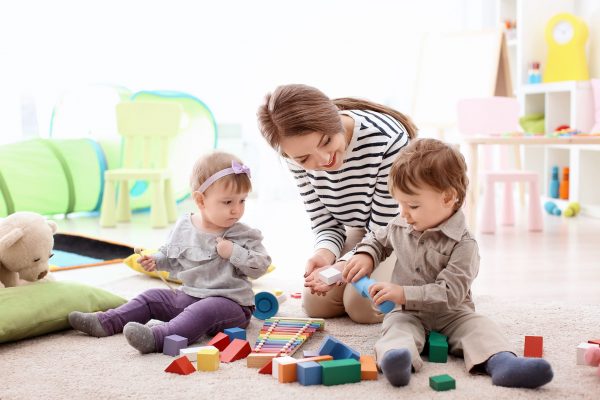 Assistante maternelle jouant avec des enfants